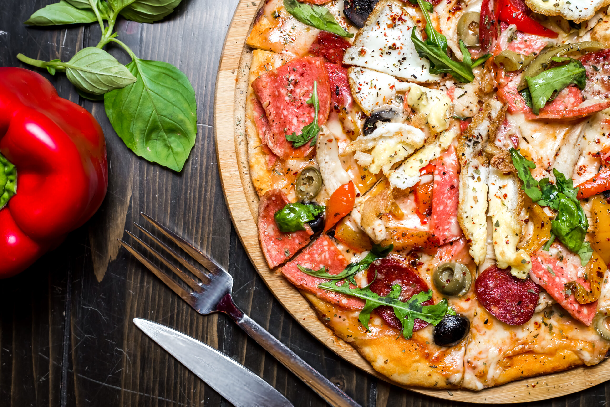 mixed pizza sausages chicken arugula olives cheese pepper top view